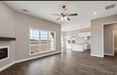Unfurnished living room with ceiling fan, dark wood-type flooring, a glass covered fireplace, and recessed lighting