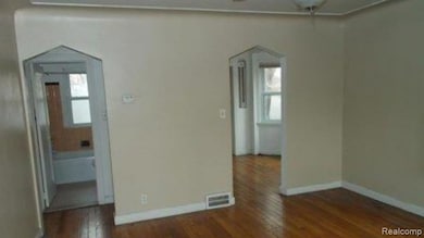 Empty room featuring dark wood finished floors, arched walkways, and ceiling fan