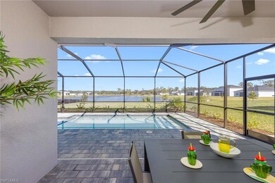 Swimming pool featuring a water view, a patio, a lanai, and a ceiling fan