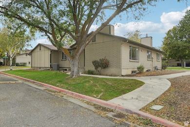 View of side of home with brick siding, a yard, and a chimney