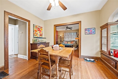 Up unit dining area with ceiling fan and light hardwood / wood-style flooring