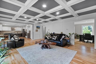 Living room featuring beam ceiling, coffered ceiling, a desk, light wood-style floors, and recessed lighting