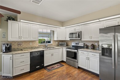 Kitchen with visible vents, a sink, dark wood-type