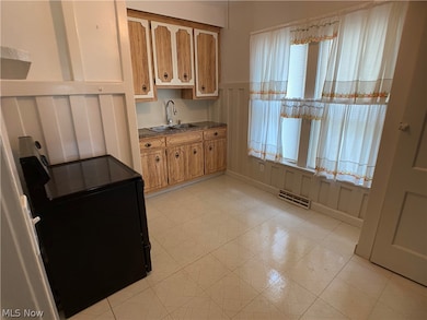 Kitchen featuring light tile floors, sink, and range