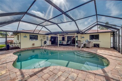Gorgeous free-form heated pool and paver decking are inviting. Back of home reveals from left: white pool bath door, pocket sliders into dining/family room, kitchen pass through window, pocket sliders into living room.