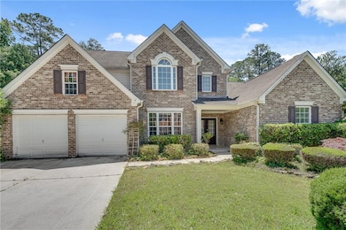 Traditional-style house with brick siding, a front lawn, concrete driveway, and a shingled roof
