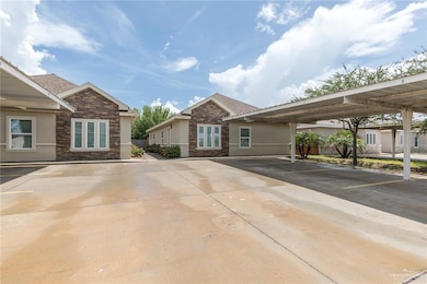 View of front facade featuring stone siding, stucco siding, and covered parking