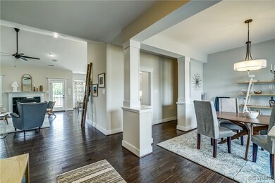 Dining room with dark wood-style flooring, a firep