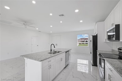 Kitchen featuring ceiling fan, sink, a center isla