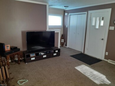 Living room view of stairs, front door and closet