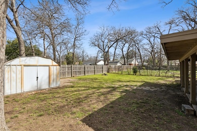 View of yard with a storage unit, a fenced backyar