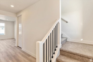 Stairs featuring recessed lighting and wood finished floors