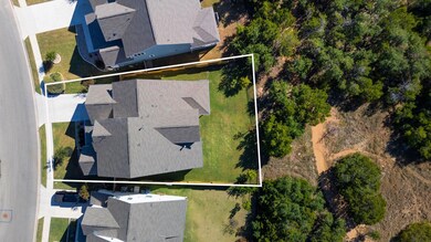 From above, you can see how beautifully this home blends into nature, with greenbelt trails weaving right behind the property.