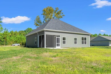 Back of house featuring a sunroom and a yard