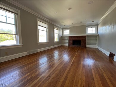 Unfurnished living room featuring dark hardwood / wood-style floors, a fireplace, and crown molding