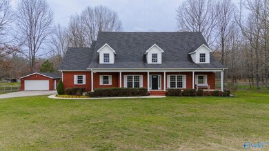 Large front lawn area where you can see the West facing covered front porch area! Great for watching sunsets!! You can also see the detached 2 car garage on the left