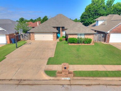 View of front of property with brick siding, a gate, concrete driveway, roof with shingles, and a garage