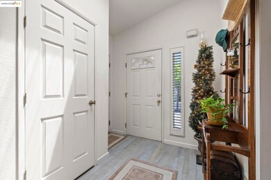 Entryway featuring light wood-type flooring and lofted ceiling