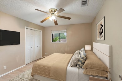 Bedroom with wood finished floors, a textured cei