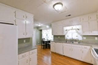 Kitchen featuring white appliances, white cabinets