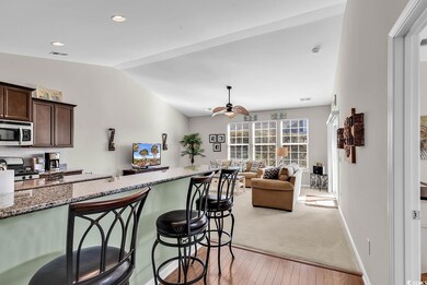 Kitchen featuring dark brown cabinetry, dark stone