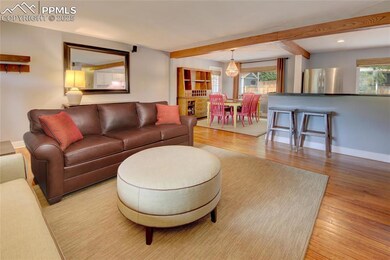 Living area with wood finished floors, beamed ceiling, and recessed lighting