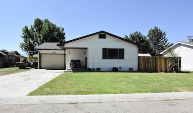Ranch-style home featuring concrete driveway and an attached garage