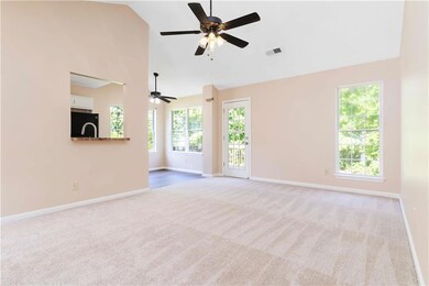 Unfurnished living room featuring carpet, baseboards, a ceiling fan, plenty of natural light, and high vaulted ceiling