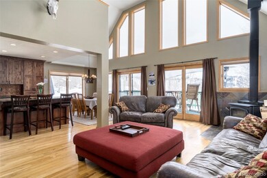 Great room has giant windows and vaulted ceilings