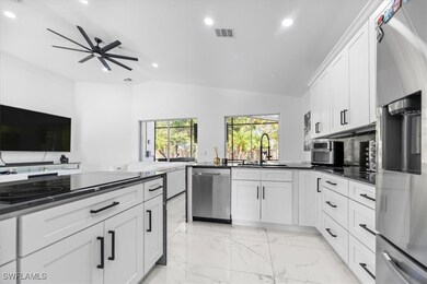 Kitchen featuring white cabinetry, sink, ceiling f