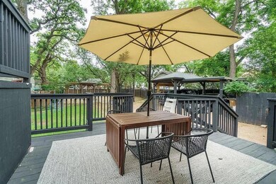 Wooden deck with a fenced backyard, a playground,