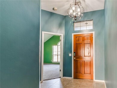 The entryway is spacious with a modern chandelier.