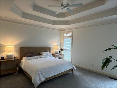 Carpeted bedroom with ceiling fan, ornamental mold