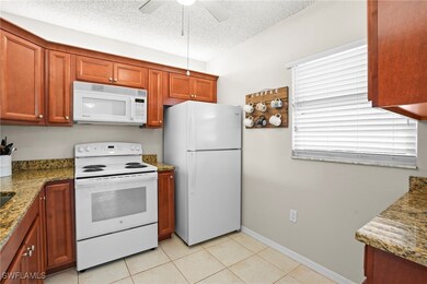 Kitchen with stone counters, a textured ceiling, c