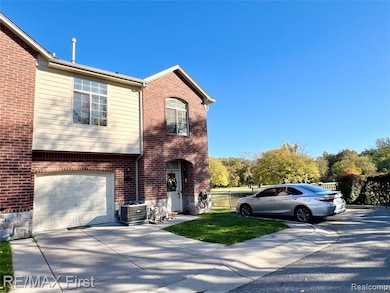 View of front of home featuring brick siding, concrete driveway, and a garage