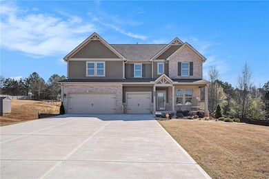 Craftsman-style home with an attached garage, brick siding, concrete driveway, a front lawn, and covered porch