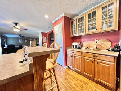 Kitchen featuring a textured ceiling, light hardwo