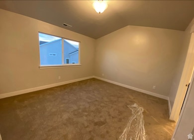 Additional living space with vaulted ceiling and carpet floors