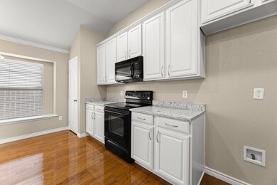 Kitchen featuring lofted ceiling, black appliances