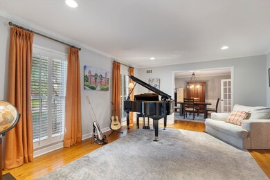 Living area with ornamental molding, wood finished floors, and recessed lighting