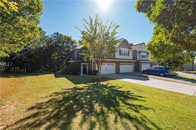 View of front facade with a front yard, concrete driveway, and an attached garage