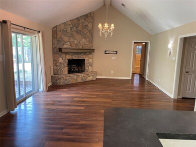 Family Room with beautiful fireplace.  Primary bedroom is in the background off hallway.  Secondary bedroom is on the left.