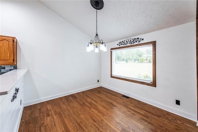 Informal diing room has vaulted ceiling and picture window.