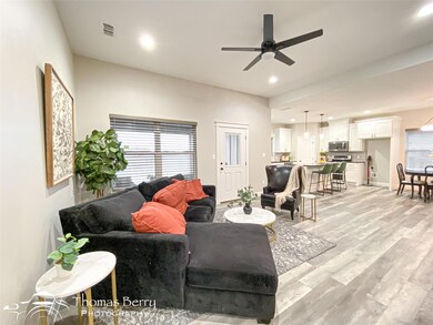 Living room featuring ceiling fan and light wood-t
