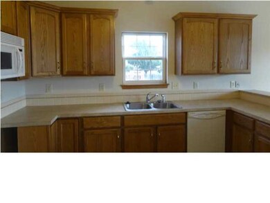 This kitchen has a neutral colored tile and space 