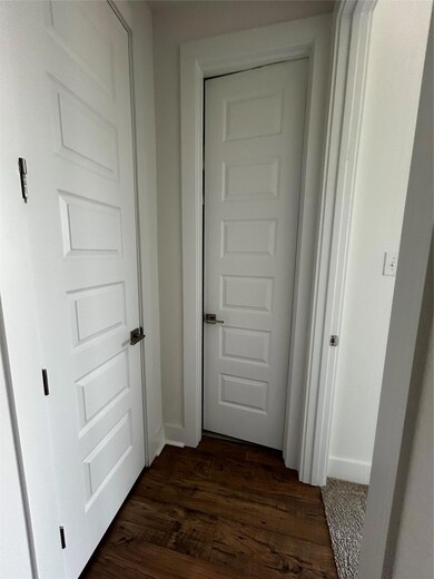 Corridor featuring baseboards and dark wood-type 