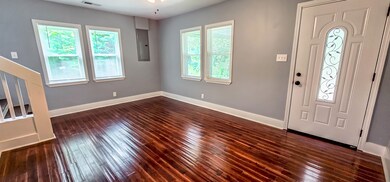 Front door opens into living room with gleaming wo
