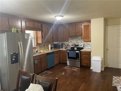Kitchen featuring dark wood-type flooring, a textu