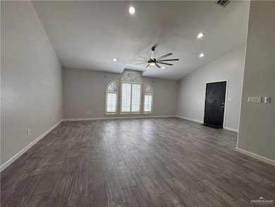 Unfurnished room with lofted ceiling, recessed lighting, baseboards, dark wood finished floors, and a ceiling fan