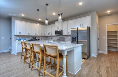 Kitchen with white cabinetry, a kitchen island wit